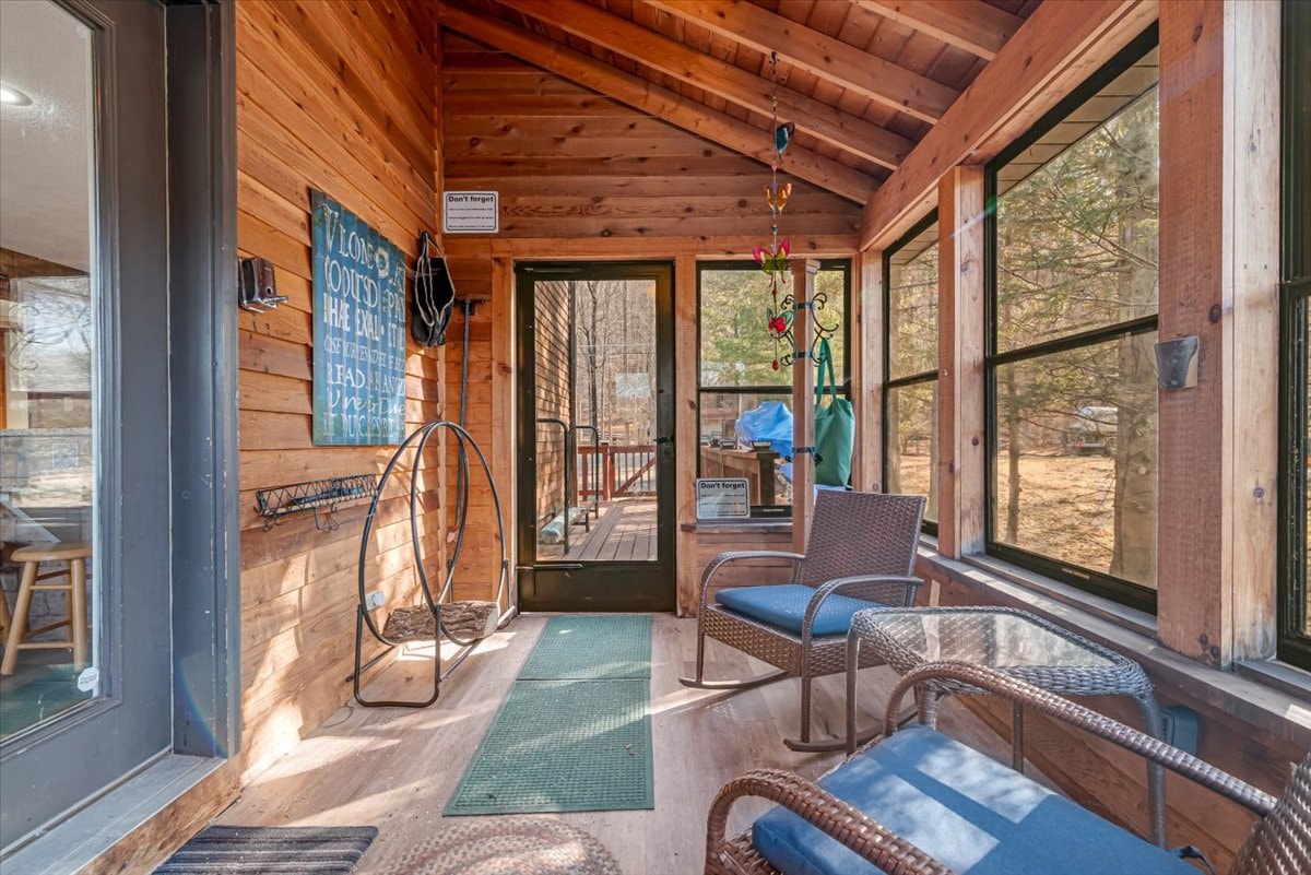 Screened porch interior with wicker rocking chairs and wood ceiling