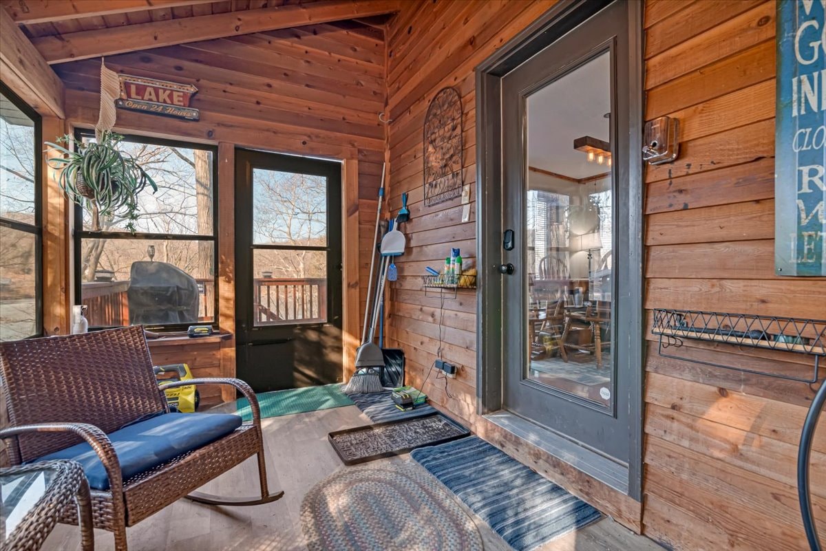 Screened porch with lake sign decor and rocking chairs