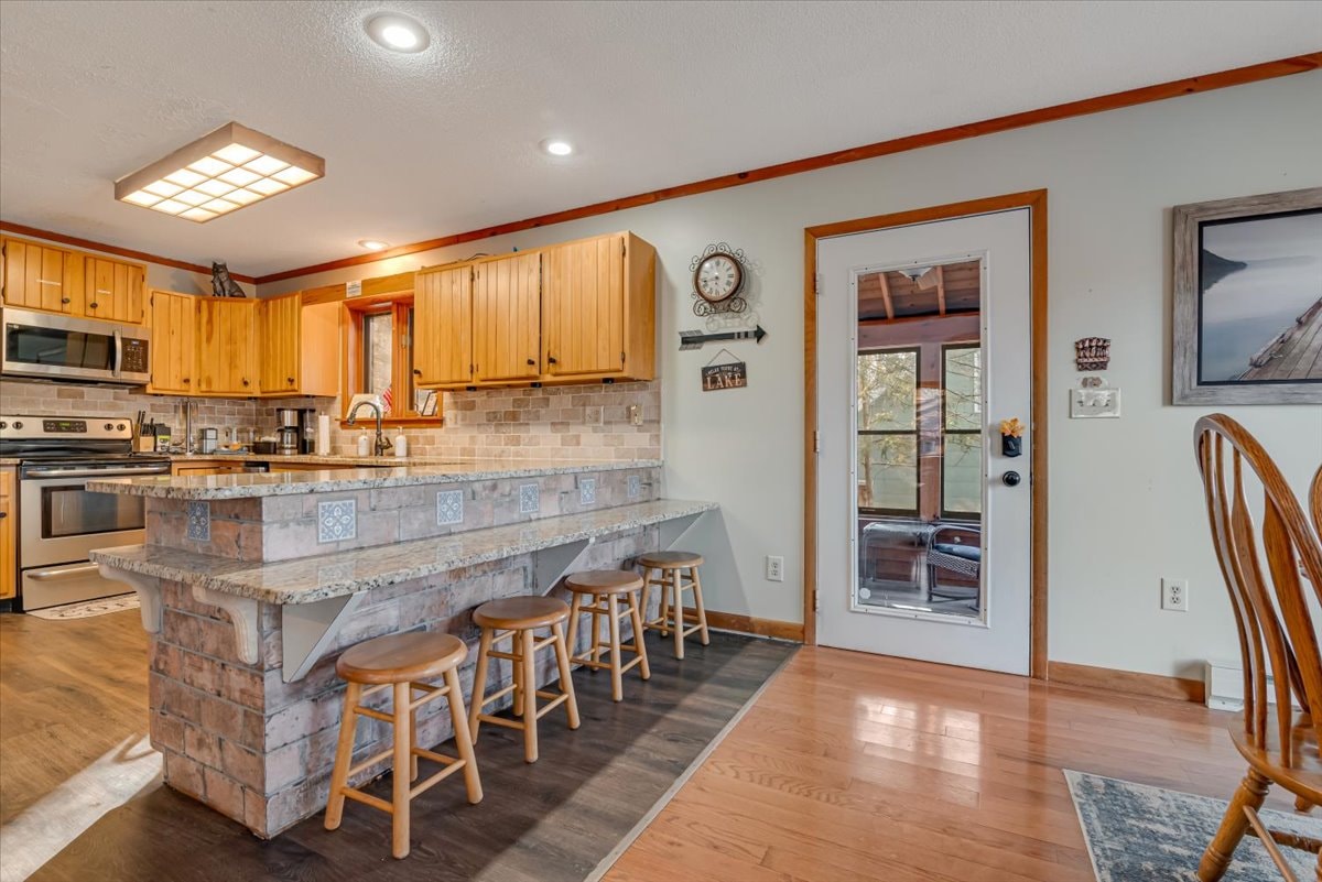 Kitchen with brick island, bar stools and stainless appliances
