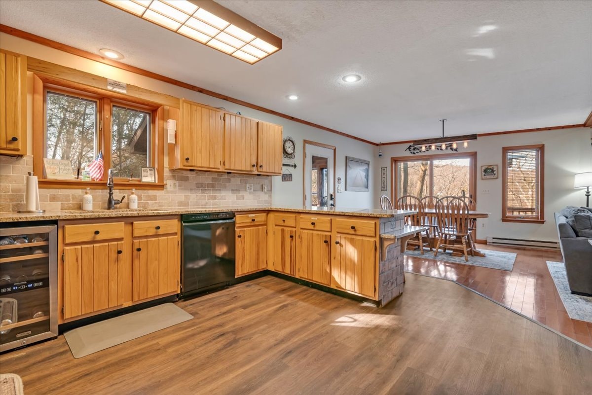 Kitchen open to dining room with hardwood floors and natural light