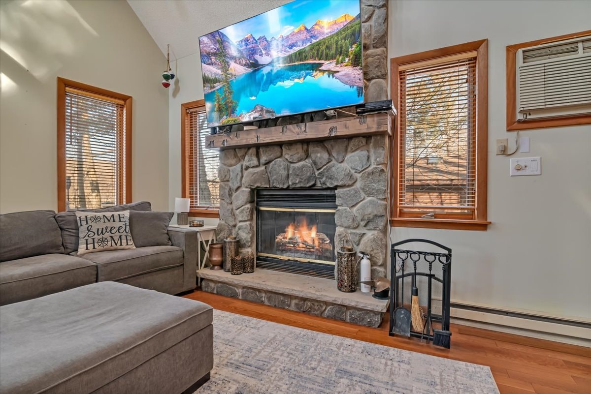 Stone fireplace close-up with roaring fire and mounted TV