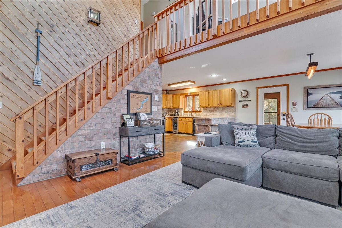 Living room with pine staircase, loft and open kitchen view