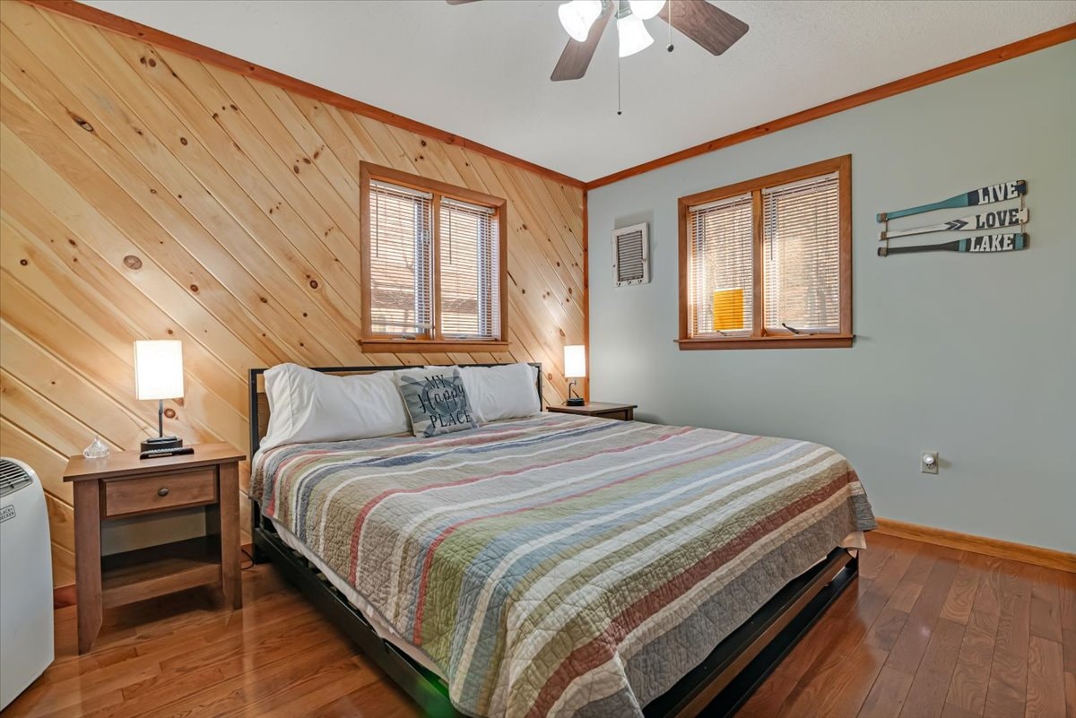 Bedroom with pine shiplap accent wall, king bed and lake decor