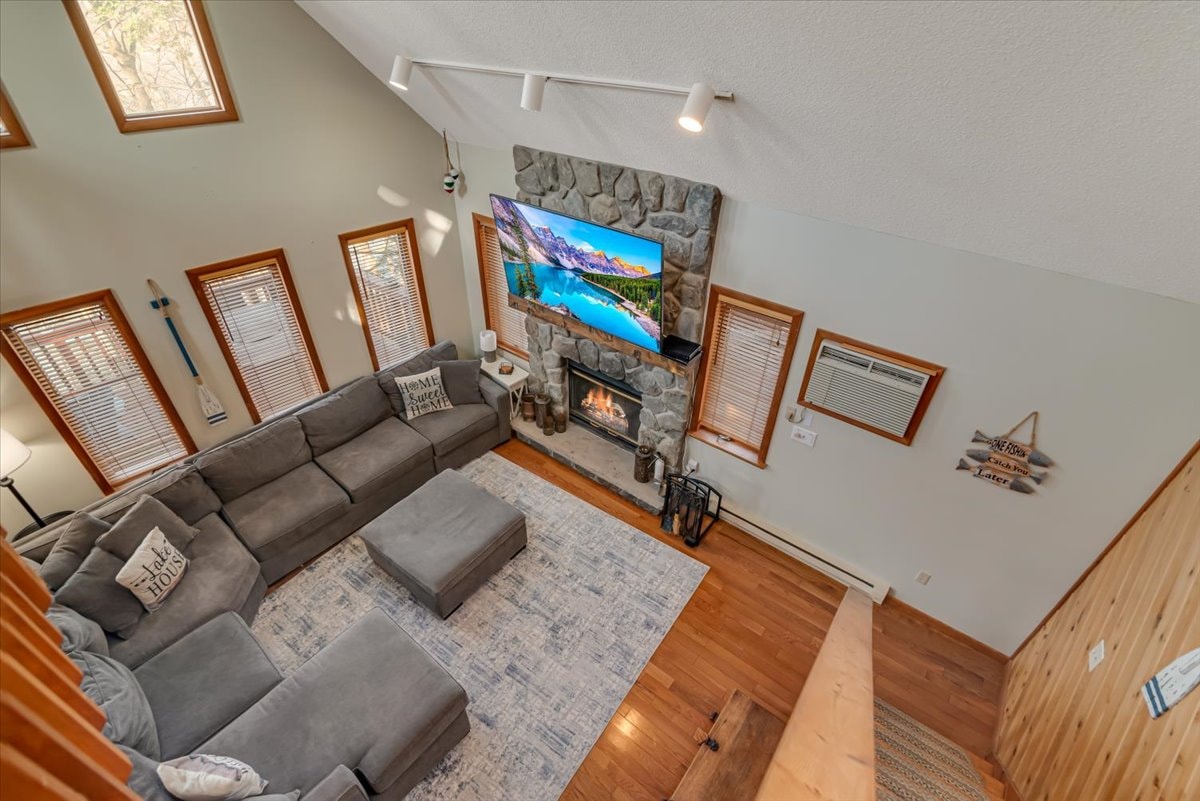Living room overhead view with stone fireplace, sectional sofa and hardwood floors