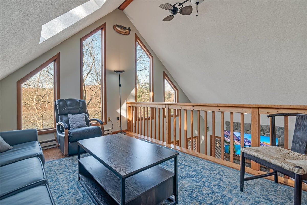 Loft lounge with recliner, coffee table and views down to stone fireplace