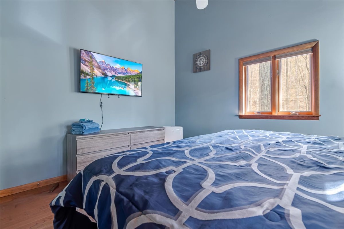 Bedroom with king bed, wall-mounted TV and compass wall decor