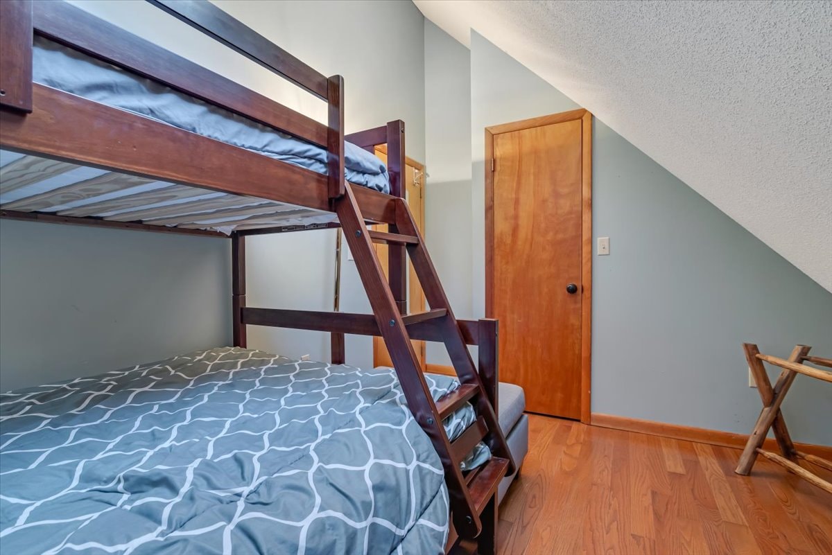 Bunk room with bunk bed, closet and sloped ceiling