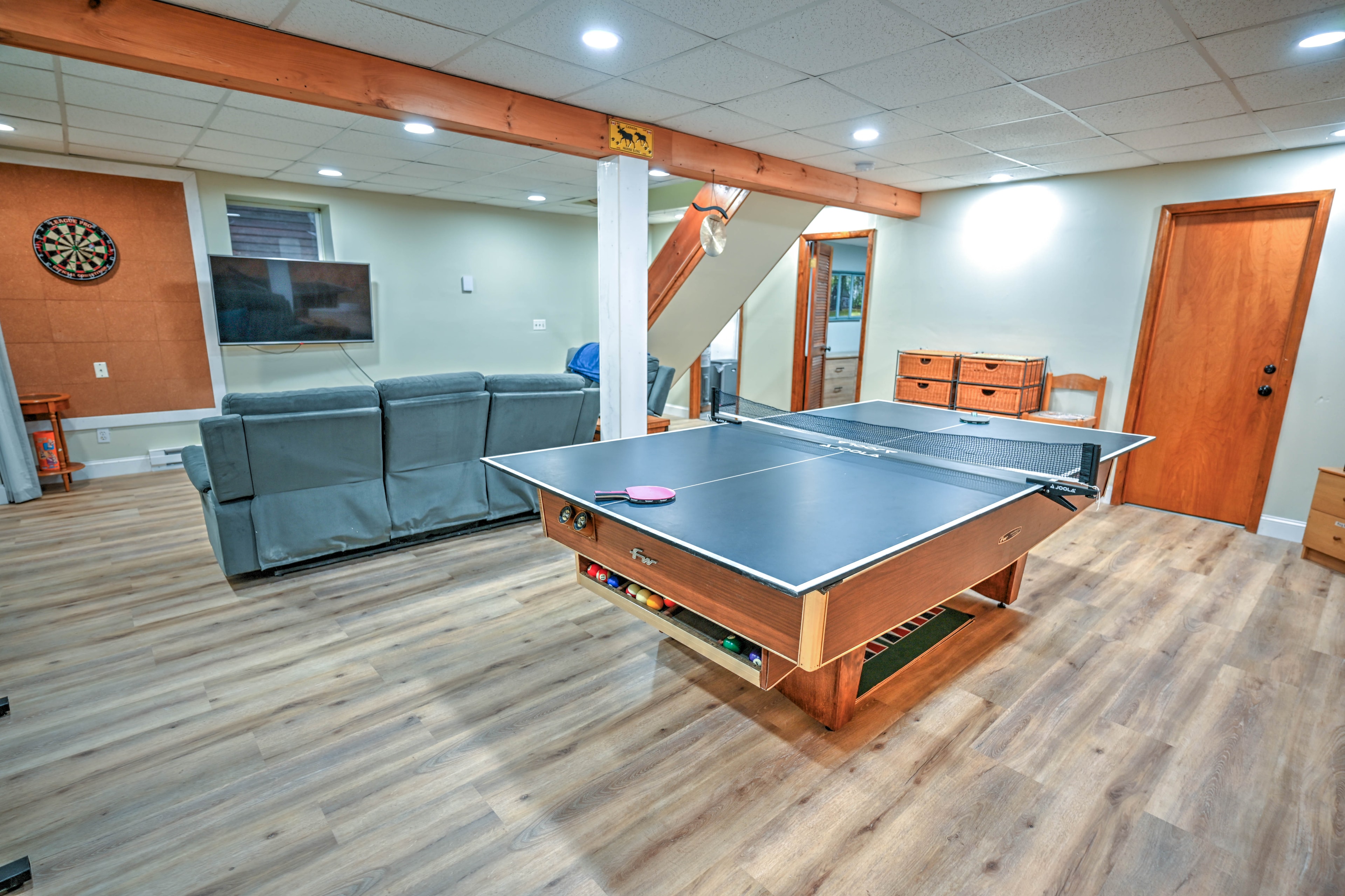 Game room with ping pong table, dartboard and wall-mounted TV