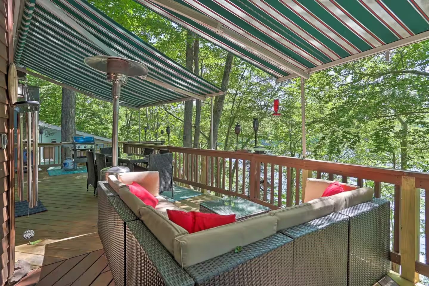 Upper deck with striped awning, sectional seating and lake views